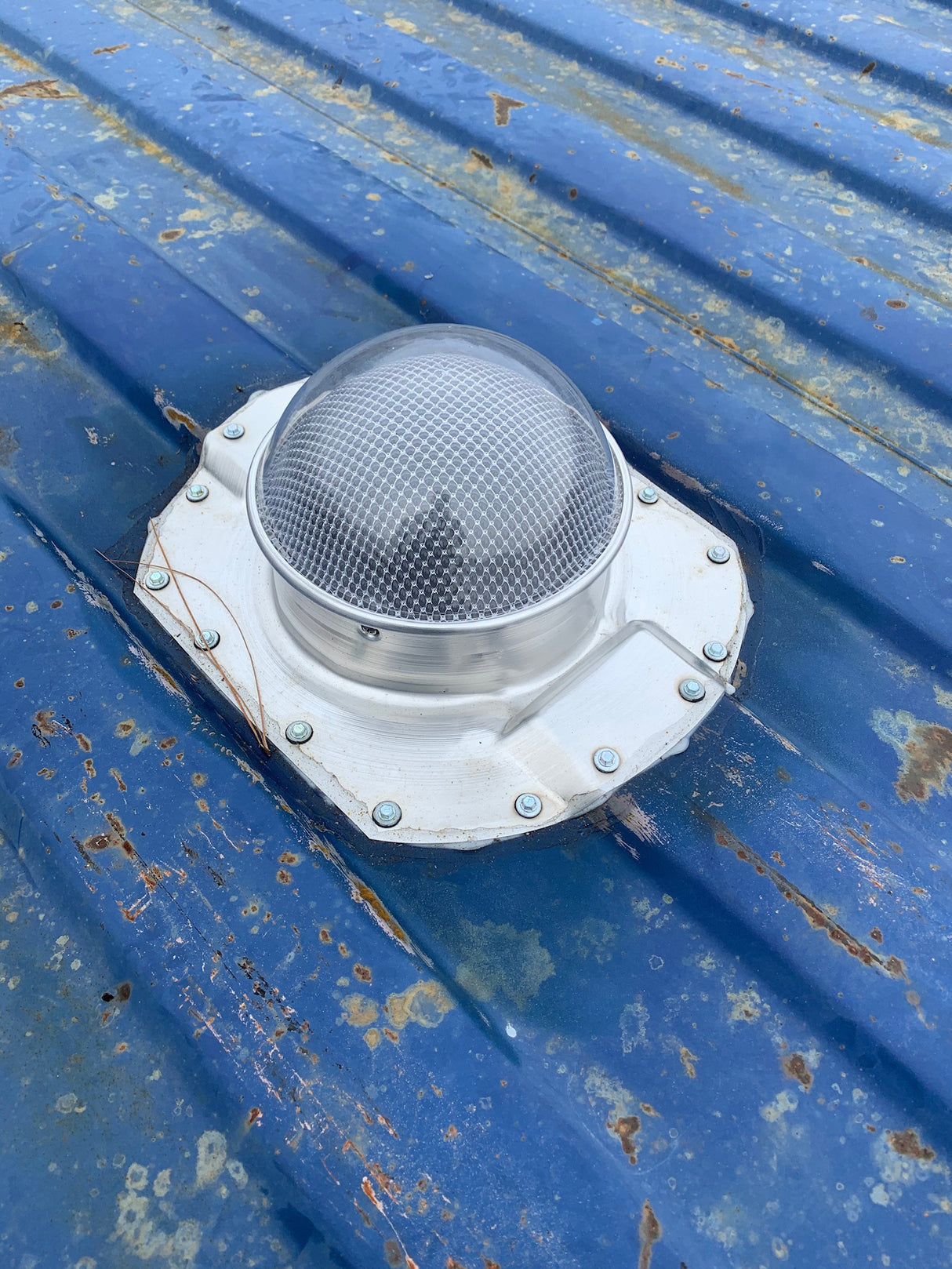 One Conex Solar LightBlaster installed on a blue shipping container's roof which has 3.5" ribs. This is a customer's install photo.