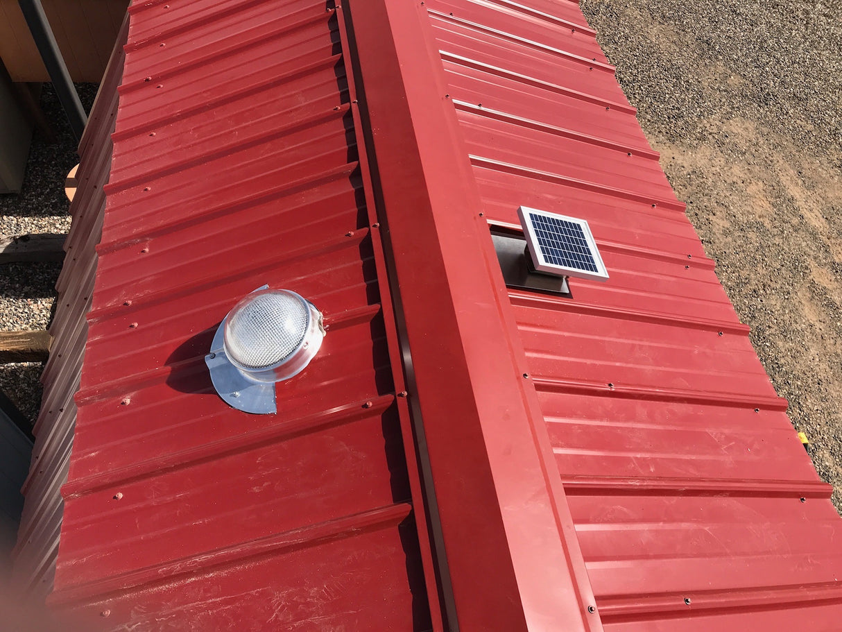 A Solar LightBlaster for Metal Roofs is installed on shed's red metal roof with a Solar Metal RidgeBlaster installed on the other side of the roof.
