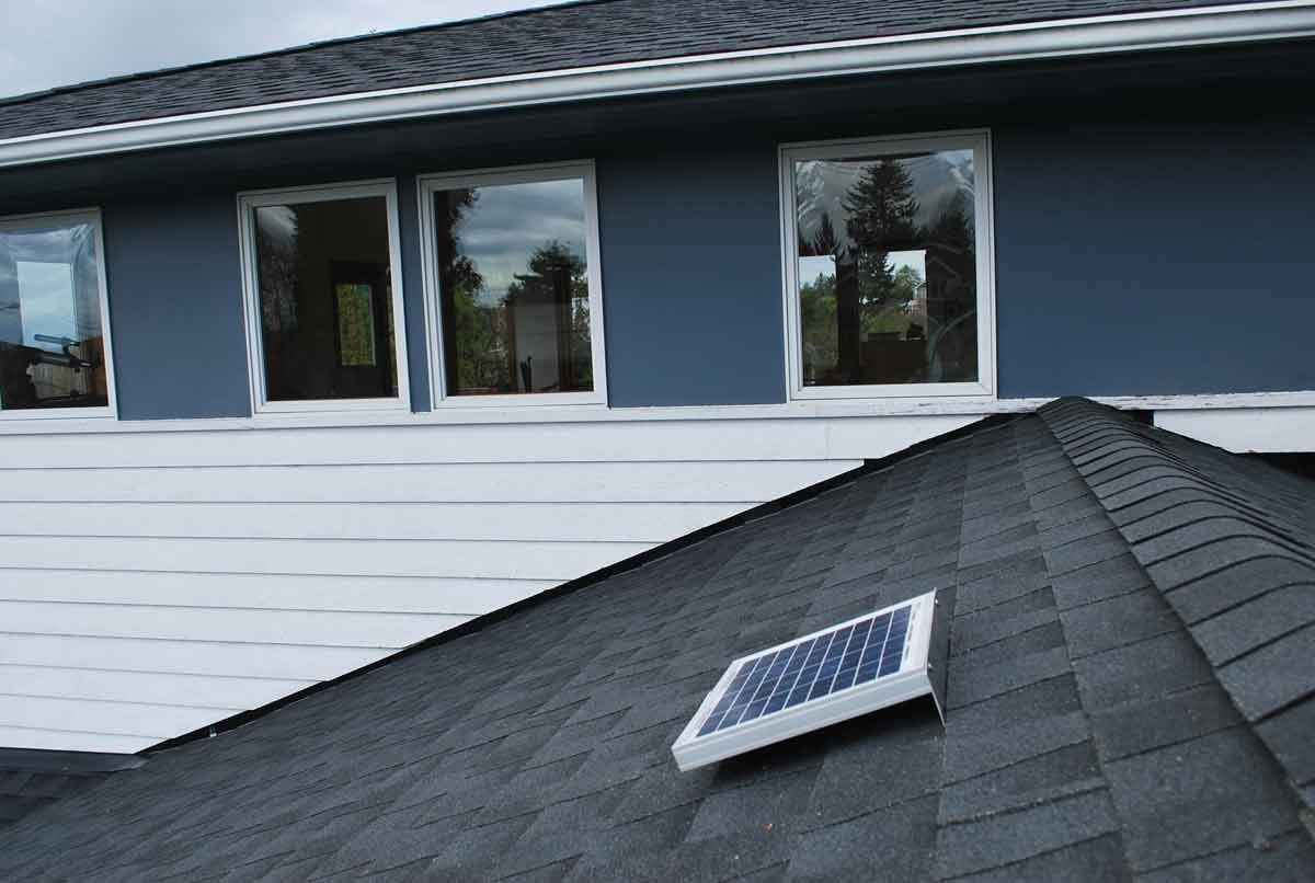 Solar RidgeBlaster has been installed on a shingled roof of a house with blue siding.