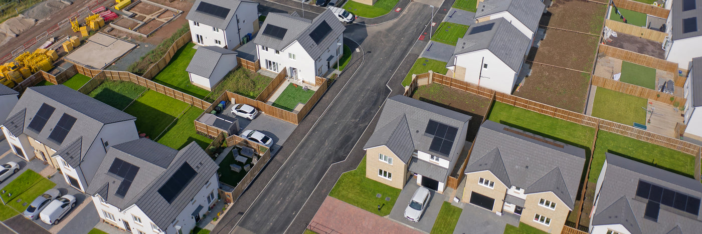Aerial view of housing development that shows several homes with solar on their roofs.