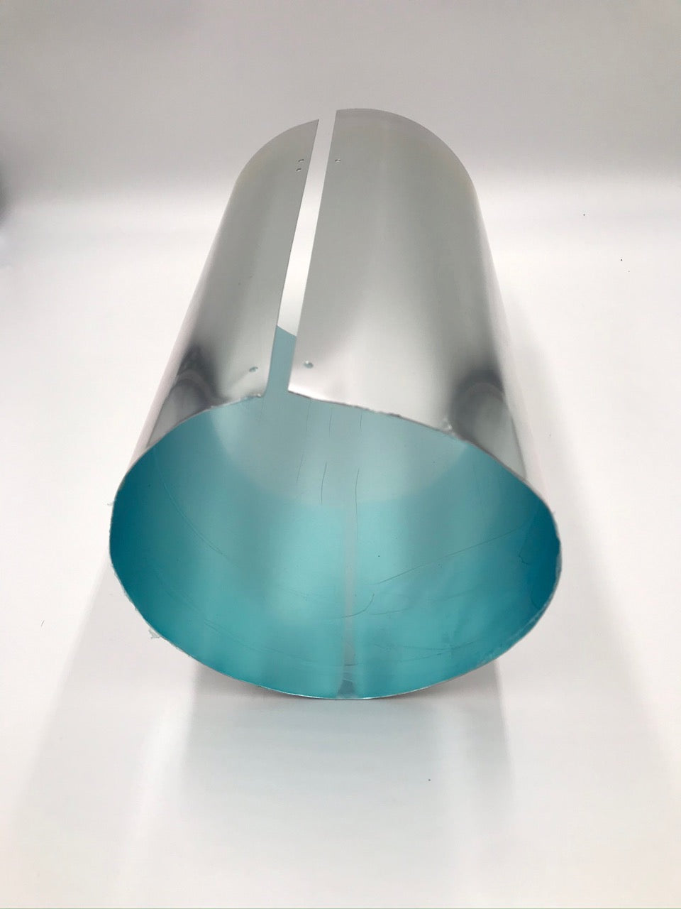 12 inch extension tube laying on its side and showing the blue protective film that is on the inside of the tube. This protective layer needs to be removed prior to installation.
