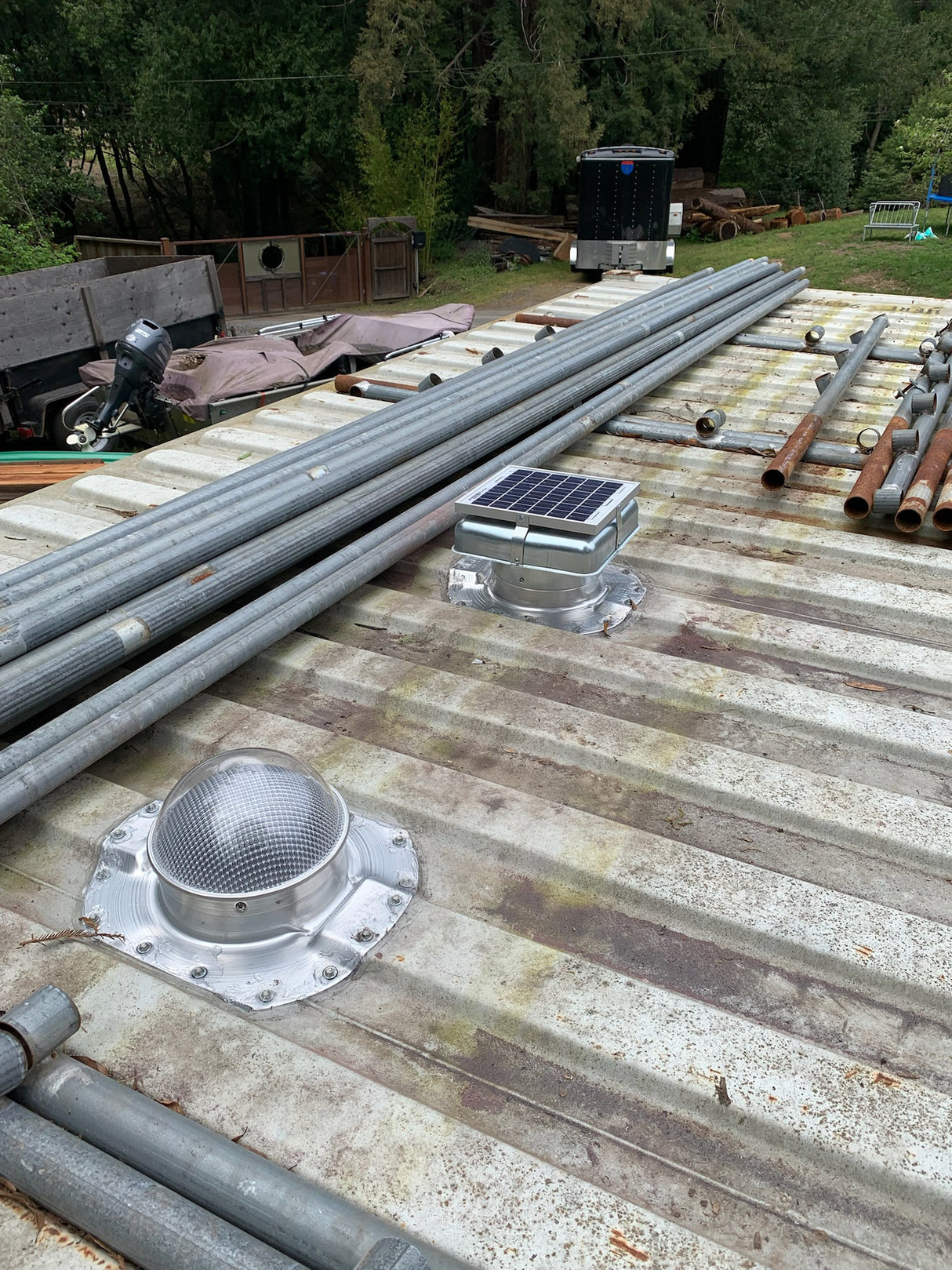 One Conex Solar Mega Roofblasters and one Conex Solar LightBlasters installed on a white shipping container's roof with pipes also on the roof. This is a customer's install photo.