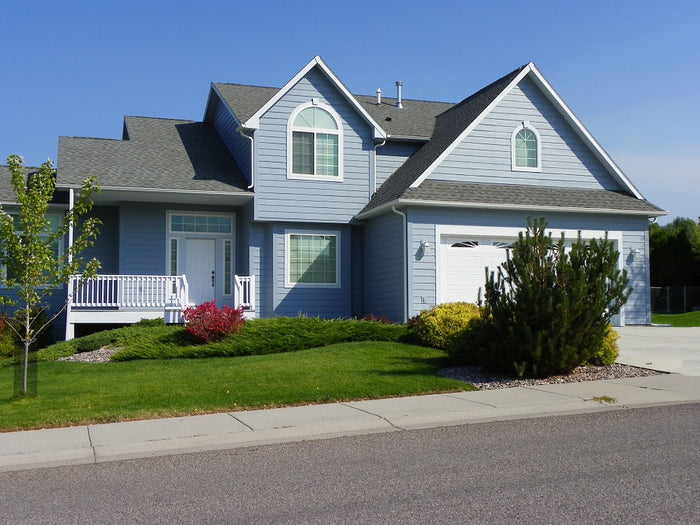 Two-story house with a blue exterior and white trim on a clear day.