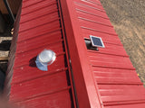 A Solar LightBlaster for Metal Roofs is installed on shed's red metal roof with a Solar Metal RidgeBlaster installed on the other side of the roof.