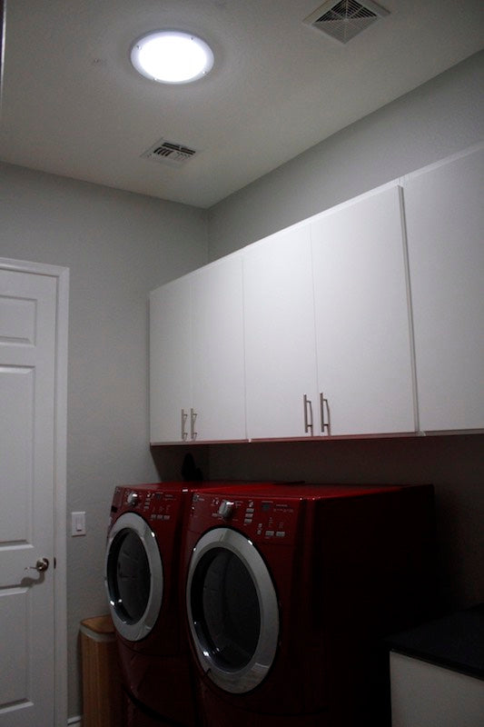 An after photo of a laundry room with a newly installed 10-inch Solar LightBlaster Tubular Skylight for Homes.