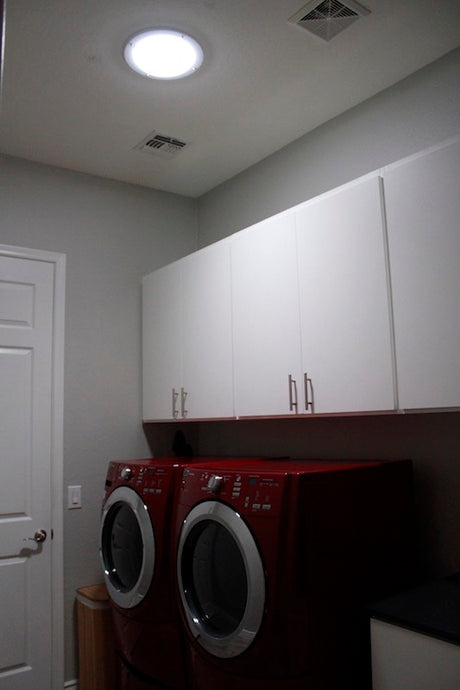 An after photo of a laundry room with a newly installed 10-inch Solar LightBlaster Tubular Skylight for Homes.