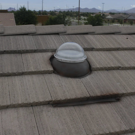 A Solar LightBlaster Tubular Skylight for Homes installed on a house with a flat tile roof.