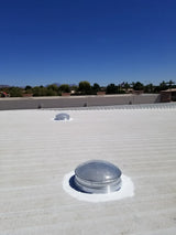 Two 28-inch Solar LightBlaster Tubular Skylights for Warehouses installed on a flat foam roof on top of a warehouse.