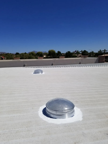Two 28-inch Solar LightBlaster Tubular Skylights for Warehouses installed on a flat foam roof on top of a warehouse.