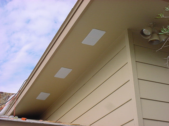 Exterior of a house with beige siding and three rectangular soffit vents.