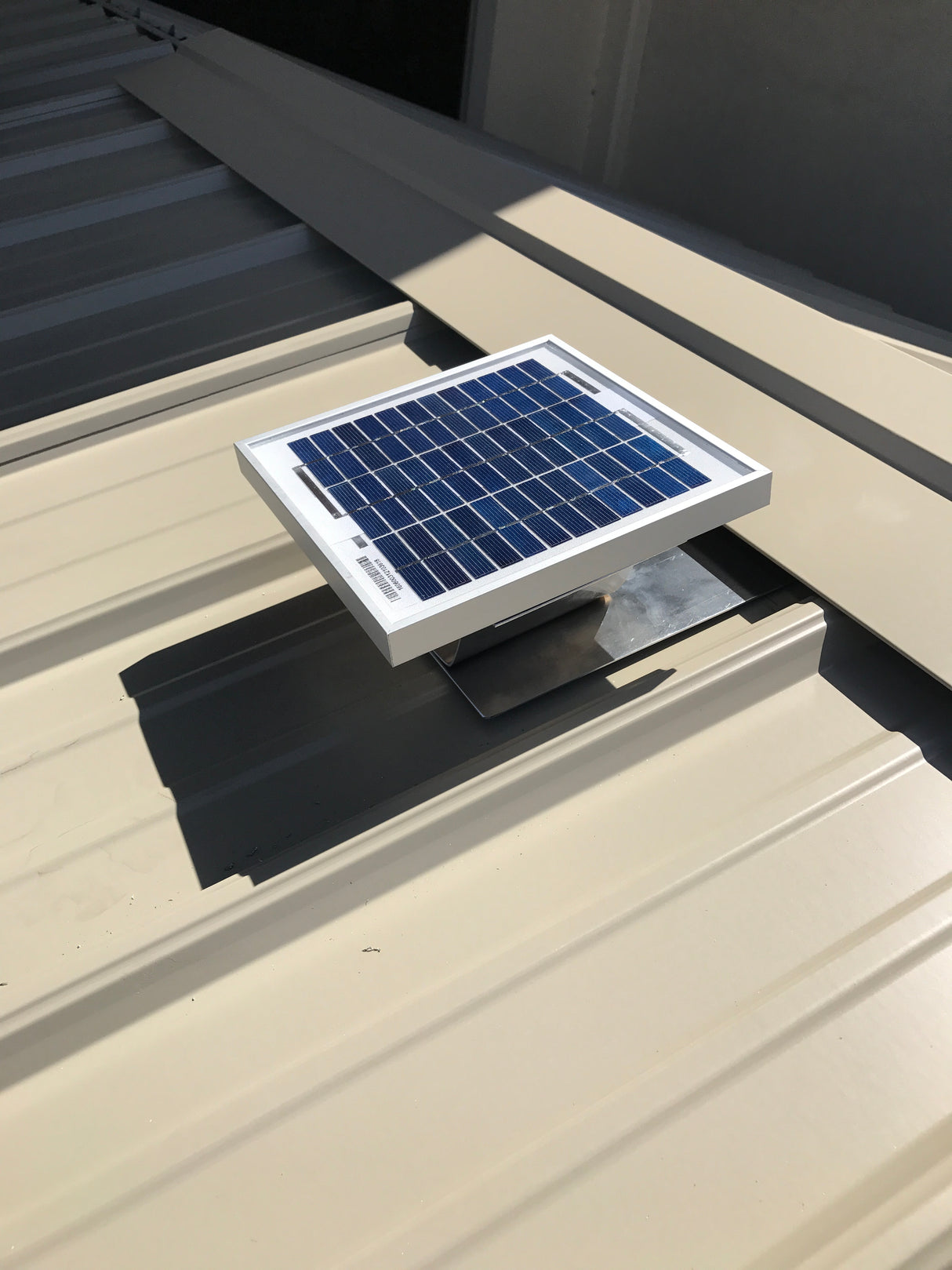 Solar Metal RidgeBlaster installed onto a shed's metal roof with the ridge cap being installed.