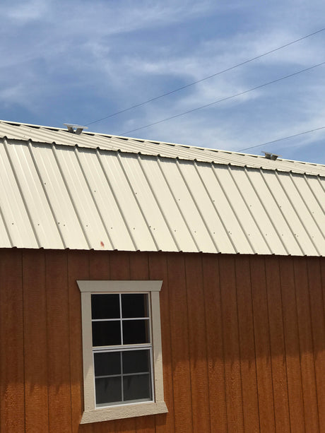 Two Solar Metal RidgeBlasters installed on a brown shed with a beige metal roof.