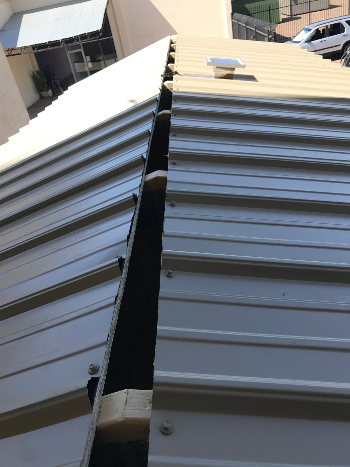 Solar Metal RidgeBlaster with all parts installed onto a shed's metal roof before the ridge cap is placed.