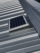 Solar RidgeBlaster has been installed on a galvanized metal roof of a shed.
