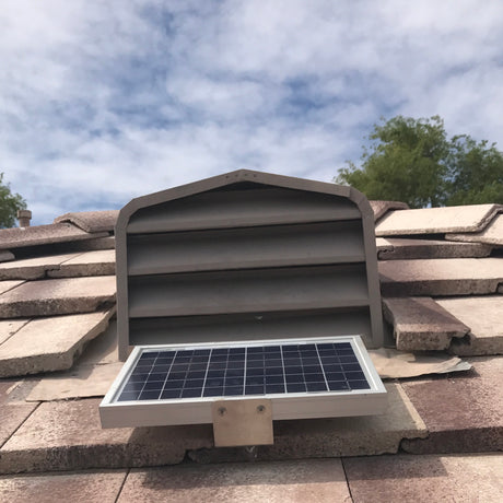 Shows a Solar Tileblaster installed on a dormer vent on a flat-tiled roof.