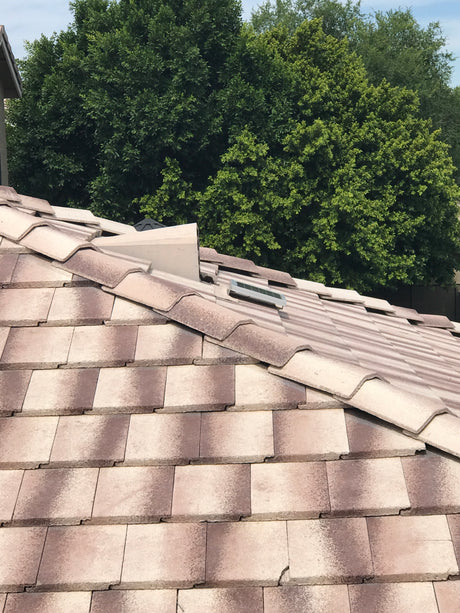 Shows a Solar Tileblaster installed on a dormer vent on a flat-tiled roof.
