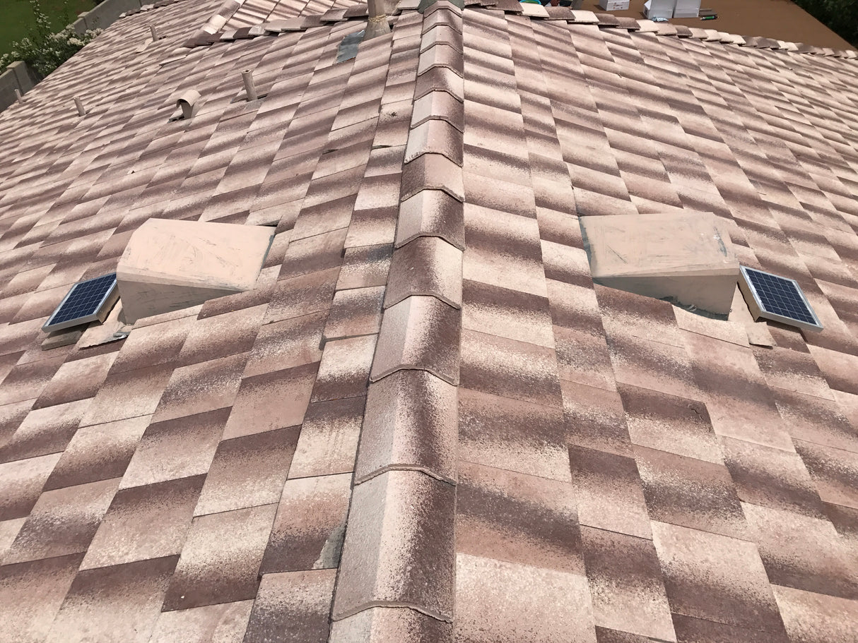 Shows two Solar Tileblaster installed on two dormer vents on a flat-tiled roof.