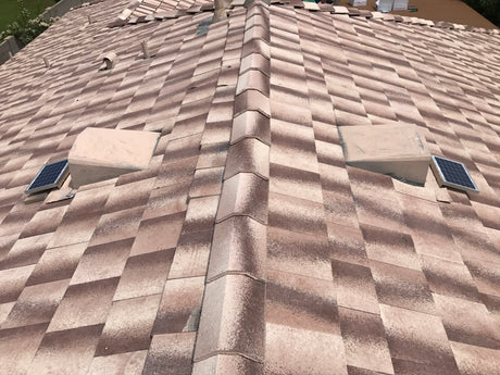 Shows two Solar Tileblaster installed on two dormer vents on a flat-tiled roof.